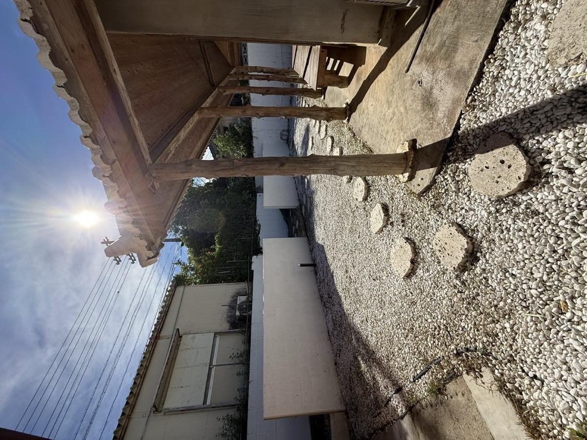 今帰仁村謝名の住宅。施工後、建物まわりの草を刈り取って整えた様子